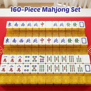 May include: A 160-piece Mahjong set featuring white tiles with blue, red, and green characters, symbols, and numbers. The tiles have translucent gold-colored bases and are arranged in four rows on a red surface. The text 160-Piece Mahjong Set is visible.