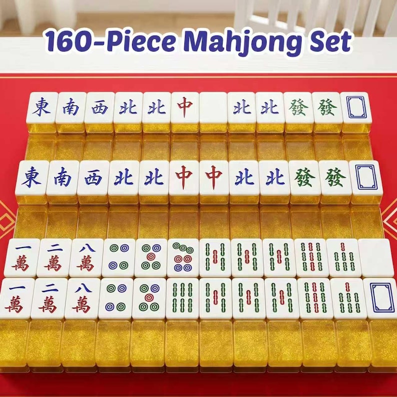 May include: A 160-piece Mahjong set featuring white tiles with blue, red, and green characters, symbols, and numbers. The tiles have translucent gold-colored bases and are arranged in four rows on a red surface. The text 160-Piece Mahjong Set is visible.
