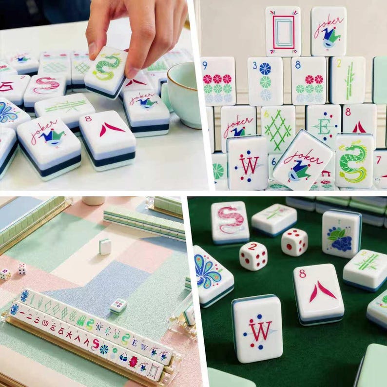 Puede incluir: Un juego de fichas de Mahjong blancas con ilustraciones coloridas de dragones, flores y personajes joker, junto con dados y soportes. Las fichas muestran varios s&iacute;mbolos, n&uacute;meros y letras en tinta roja, verde y azul sobre una superficie lisa.