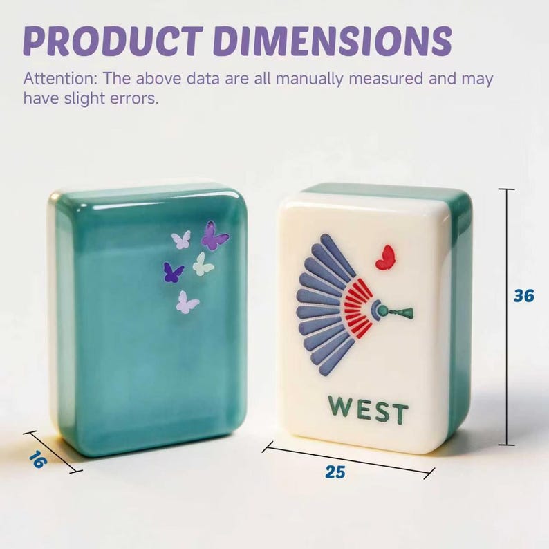 May include: Two rectangular mahjong tiles with dimensions 36mm by 25mm by 16mm. One tile is teal with small purple and white butterfly graphics. The other is white with a teal and red fan graphic, a small red butterfly, and the text WEST.