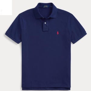 Könnte beinhalten: Ein marineblaues kurzärmeliges Poloshirt mit klassischem Kragen, einer Knopfleiste mit zwei Knöpfen und einem kleinen roten gestickten Logo einer Person auf einem Pferd auf der linken Brust. Das innere Nackenetikett zeigt den Text Polo Ralph Lauren.