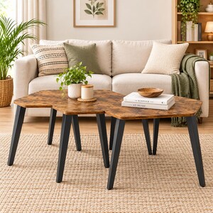 May include: A set of two nesting coffee tables with irregular hexagonal wooden tops featuring a brown wood grain finish and black metal legs. The tables are arranged together, with one slightly overlapping the other, creating a tiered surface.