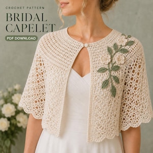 May include: A cream-colored crochet capelet featuring a delicate openwork pattern, a single button closure at the neckline, and an appliqué of three small white flowers with green leaves on the right side. Text reads: CROCHET PATTERN BRIDAL CAPELET PDF DOWNLOAD.