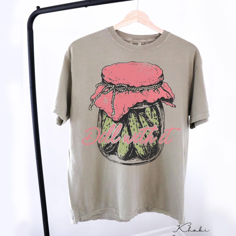 A gray t-shirt with a graphic design of a jar of pickles and the word "Dill" printed on it.