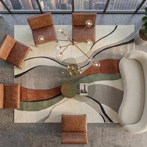 May include: A top-down view of a living room set featuring a curved cream sofa, four brown leather armchairs, and a round glass coffee table. A large area rug displays abstract wavy bands of cream, rust orange, olive green, and charcoal gray.