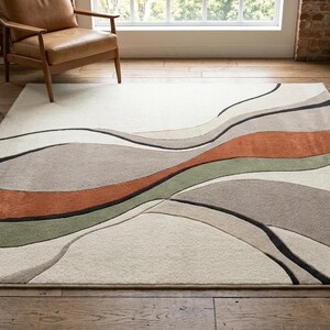 May include: A rectangular area rug featuring a cream-colored base with flowing, organic wave patterns in shades of terracotta orange, sage green, taupe, and charcoal gray. The design consists of layered, curved sections that create a sense of movement.