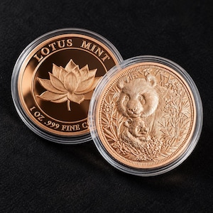 Op de afbeelding: Twee koperkleurige ronde munten in doorzichtige beschermcapsules. De ene munt toont een lotusbloem met de tekst LOTUS MINT en 1 OZ .999 FINE COPPER. De andere munt toont een panda met een jong omringd door bamboe en bladeren.