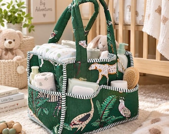 May include: A dark green quilted fabric diaper caddy featuring a jungle animal print with zebras, leopards, and birds. The organizer has two sturdy handles, multiple exterior pockets, and a striped trim, filled with baby care essentials.