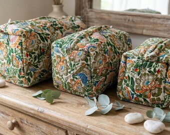 May include: Three rectangular quilted pouches of varying sizes, each featuring a cream-colored fabric base with a dense, colorful floral and bird pattern in shades of green, orange, blue, and pink, with a top zipper closure on each item.