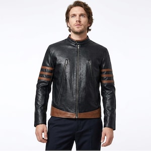 May include: A black leather jacket featuring a stand-up collar, a full-length front zipper, and two diagonal zippered chest pockets. The sleeves are accented with three horizontal brown stripes, and the hem is finished with a brown leather panel.