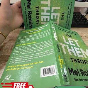 May include: A spiral-bound book titled The Let Them Theory by Mel Robbins with a bright green cover. The back cover features descriptive text about the book's content, a barcode, and the author's signature in white against the green background.
