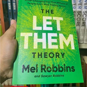 May include: A bright green book titled The Let Them Theory by Mel Robbins and Sawyer Robbins. The cover features white text with a yellow stippled sunburst effect. It includes the text #1 New York Times Bestseller and A Life-Changing Tool That Millions of People Can't Stop Talking About.