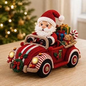 Op de afbeelding: Een gehaakt kerstmanfiguur in een rode auto met witte strepen. De auto heeft een groene krans aan de voorzijde, oplichtende koplampen en een kofferbak gevuld met ingepakte cadeautjes, een kleine teddybeer en een rood-witte zuurstok.