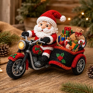 Op de afbeelding: Een gehaakt kerstmanfiguur op een zwarte motorfiets met zijspan. De kerstman draagt een rood-wit pak en een muts. Het zijspan is gevuld met diverse gehaakte cadeautjes, een teddybeer en een zuurstok. De motor is versierd met hulstmotieven.
