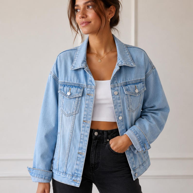 May include: A light blue denim jacket featuring a classic collar, long sleeves with buttoned cuffs, and two chest pockets with button-down flaps. The jacket has a front button closure with silver-toned metal buttons and a slightly distressed finish.