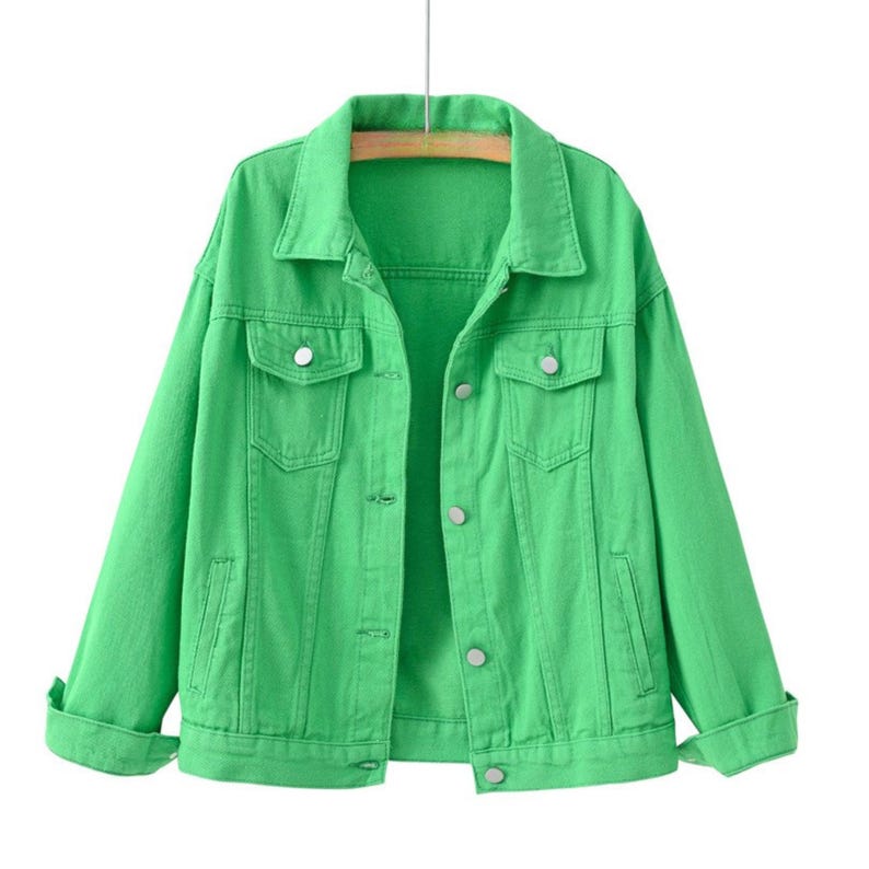 May include: A bright green denim jacket featuring a classic collar, long sleeves with buttoned cuffs, and a front button closure. The jacket includes two chest pockets with buttoned flaps and two vertical side pockets, all finished with silver buttons.