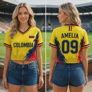 Peut inclure: Un maillot court jaune, bleu et rouge avec le texte COLOMBIA à l'avant et AMELIA 09 à l'arrière. Le design comprend un petit emblème du drapeau colombien, un graphique de ligne d'horizon et un short en jean bleu à ourlet effiloché.