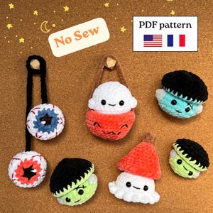 Peut inclure: Un ensemble de six peluches crochetées comprenant deux globes oculaires sur un cordon noir, une créature blanche et orange dans une pochette, deux monstres verts à cheveux noirs et une figurine en forme de champignon blanc et orange.