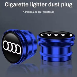 May include: Two blue metal cigarette lighter dust plugs featuring the white Audi four-ring logo on a black circular face. The text Cigarette lighter dust plug and Abrasion and tear resistance is visible at the top of the image.