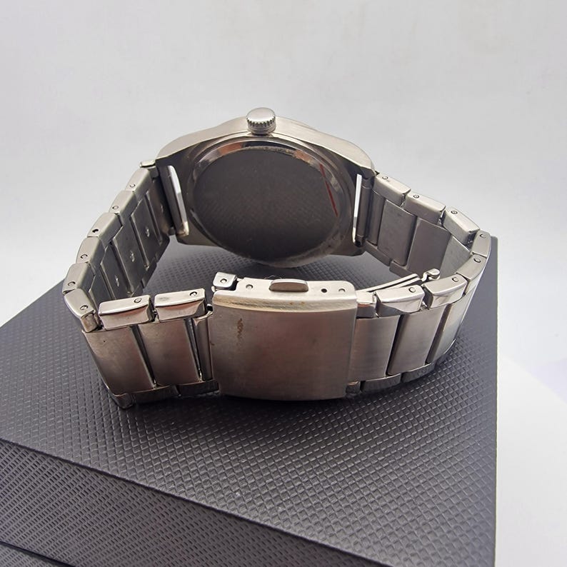 A authentic pre-owned Ben Sherman BS095 Men's Quartz Watch. Featuring a unique brushed silver analogue display, this timepiece stands out with its striking blue-accented numerical markers and precise 3-hand design. The durable stainless steel case is paired with a matching silver-toned metal link bracelet,