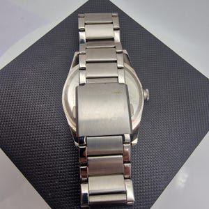 A authentic pre-owned Ben Sherman BS095 Men's Quartz Watch. Featuring a unique brushed silver analogue display, this timepiece stands out with its striking blue-accented numerical markers and precise 3-hand design. The durable stainless steel case is paired with a matching silver-toned metal link bracelet,