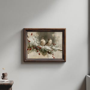 May include: A framed wall art print featuring two small birds perched on a snow-covered pine branch with bright red berries. The artwork is enclosed in a dark brown wooden frame with a textured finish, set against a neutral light gray wall.