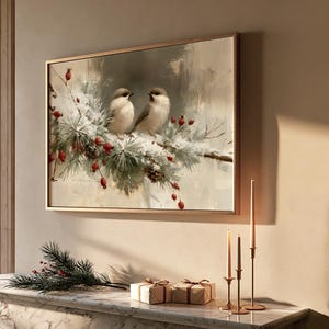 May include: A rectangular wall art print in a thin gold frame depicting two small beige birds perched on a snow-covered pine branch with red berries. The painting features soft, muted tones of white, gray, and green, capturing a winter scene.