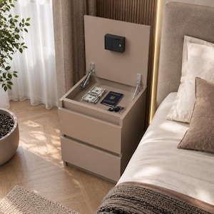 May include: A beige bedside table with two lower drawers and a top compartment that opens upward. The interior of the top compartment contains a black electronic safe mounted to the lid, with a stack of US currency, a passport, and keys inside.