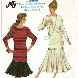 May include: Simplicity sewing pattern 8165, size NN (10-16). The envelope features illustrations of two dress variations: one with a red and black striped long-sleeve top and black skirt, and one solid cream long-sleeve dress with a flared hem.