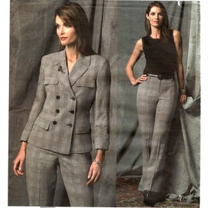 May include: A gray plaid suit with a double-breasted jacket and matching pants. The jacket has two chest pockets and four buttons. The model is also wearing a black top and gray plaid pants with a black belt.