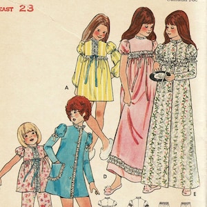 May include: Vintage sewing pattern featuring illustrations of children's sleepwear. The designs include a yellow striped dress, a pink nightgown, a floral robe, and a blue coat. The pattern is labeled "EAST 23".