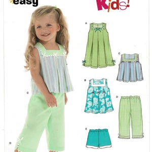 May include: New Look sewing pattern 6473 for kids, size A 1/2-4. The envelope features illustrations of five clothing variations including sleeveless tops with square necklines, cropped pants, and shorts with bow and lace trim details.