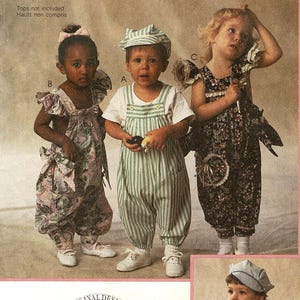 May include: Three children wearing vintage-style outfits. One child wears a striped green and white overall with a matching cap. Another child is in a floral print jumpsuit with a large bow. The third child is in a dark floral jumpsuit. All wear white shoes.