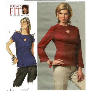 May include: A sewing pattern titled "Today's Fit by Sandra Betzina" featuring illustrations of two women's tops. One is a short-sleeved, dark blue top with a diamond-shaped cutout. The other is a long-sleeved, red top with a similar cutout.