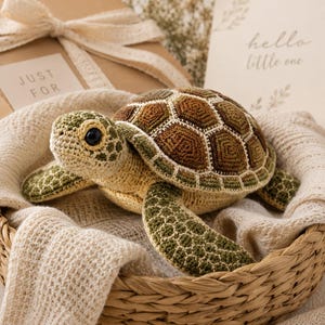 Pu&ograve; includere: Un giocattolo a forma di tartaruga marina all'uncinetto con parte inferiore color crema, testa e pinne verde oliva e un guscio composto da toppe esagonali marroni e verdi delineate con filo bianco. La tartaruga ha due occhi in plastica nera.