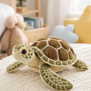 Pu&ograve; includere: Un peluche a forma di tartaruga marina realizzato all'uncinetto, con testa e pinne beige chiaro e dettagli verde scuro. Il guscio &egrave; composto da toppe esagonali nei toni del marrone e del verde oliva, rifinite con cuciture in filo color crema.