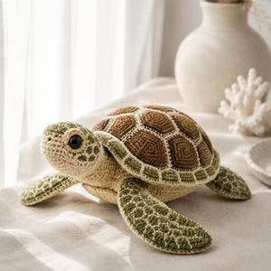 Pu&ograve; includere: Un peluche a forma di tartaruga marina realizzato all'uncinetto, con parte inferiore e testa color crema e dettagli verdi. Il guscio &egrave; composto da motivi esagonali marroni e verde scuro bordati con filo bianco. Occhi scuri e lucidi.