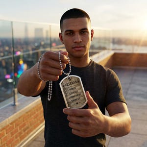 May include: A silver-toned metal dog tag pendant on a beaded ball chain. The tag features a weathered American flag background with the text VETERAN, HONOR, COURAGE, COMMITMENT, SACRIFICE, and two small stars printed in black ink on the front surface.