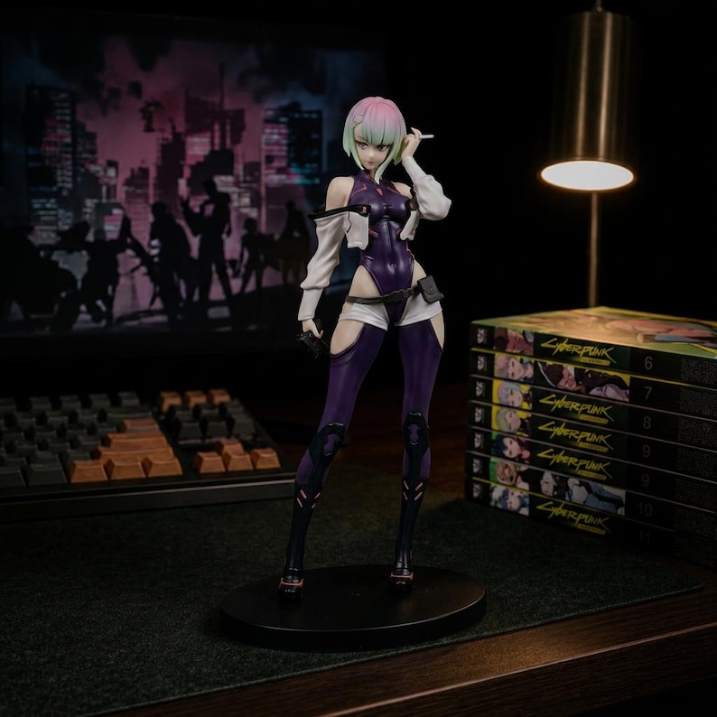 Puede incluir: Una figura de personaje estilo anime de pie con cabello corto rosa y verde, vistiendo un body morado oscuro, chaqueta corta blanca y leggings oscuros. La figura sostiene un objeto peque&ntilde;o cerca de la cara sobre una base circular negra.
