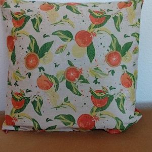Peut inclure: Un coussin carré arborant un motif répétitif d'agrumes orange vif, de feuilles vertes et de petites fleurs blanches sur un fond en tissu beige clair. Le design comprend à la fois des oranges entières et des tranches d'agrumes.