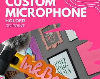 Könnte beinhalten: Ein 3D-gedruckter gelber Mikrofonhalter mit dem rosa Schriftzug InkBorrable. Der Halter ist an einem schwarzen Mikrofon mit grauem, flauschigem Windschutz befestigt. Das Design zeigt ein markantes rosa Logo in Schreibschrift auf der gelben Basis.