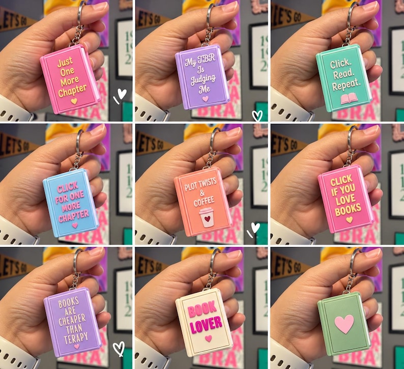 May include: A collection of nine rectangular book-shaped keychains in various pastel colors, each featuring a metal ring and unique text or symbols including phrases like Just One More Chapter, My TBR Is Judging Me, and Book Lover with heart icons.