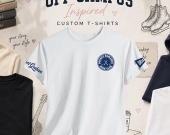 Könnte beinhalten: Ein weißes kurzärmeliges T-Shirt mit einem kreisförmigen dunkelblauen Logo auf der Brust, das Hockey Romance Book Club mit gekreuzten Hockeyschlägern zeigt. Der rechte Ärmel trägt den Schriftzug Briar und der linke Ärmel den Namen Janet Graham.