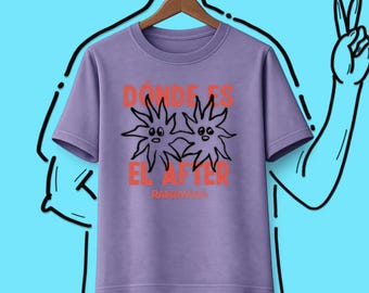Könnte beinhalten: Ein lavendelfarbenes Kurzarm-T-Shirt mit einer Grafik aus zwei schwarzen Strichmännchen-Sonnen mit Gesichtern. Der Text DÓNDE ES EL AFTER ist in Orange über und unter den Sonnen gedruckt, mit dem Wort RAHAYANA in kleineren orangen Buchstaben.