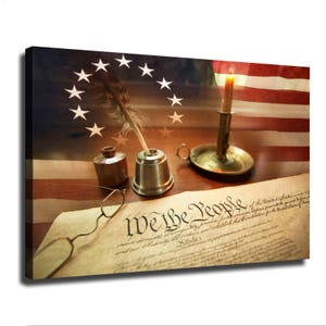 May include: A canvas print featuring a parchment document with the text We the People, a metal inkwell with a quill pen, a brass candlestick with a lit candle, and a pair of wire-rimmed spectacles, all set against a background of the American flag.