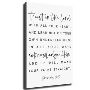 May include: A rectangular white canvas wall art piece featuring black text that reads: Trust in the Lord with all your heart, and lean not on your own understanding; in all your ways acknowledge Him, and He will make your paths straight. Proverbs 3:5.