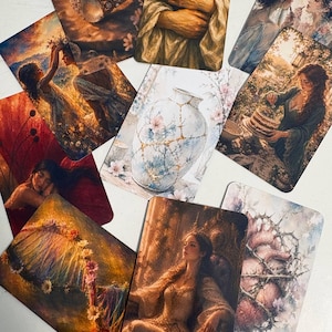 Op de afbeelding: Een verzameling rechthoekige kunstkaarten met diverse illustraties, waaronder een gouden ring, een persoon die een boek vasthoudt, een vaas in kintsugi-stijl, een persoon met een taart, een bloemenboog, een zittende figuur en een hart omringd door doornige ranken.
