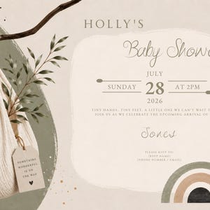 Pu&ograve; includere: Un invito per baby shower con una culla sospesa in tessuto beige, un coniglietto di peluche, un ramo verde e un arcobaleno. Il testo include Holly's Baby Shower, Sunday July 28 2026 at 2pm, Jones e Something Wonderful Is On The Way.