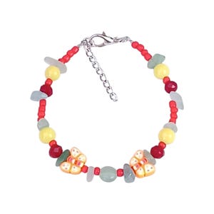 Op de afbeelding: Een kralenarmband met kleine rode ronde kralen, grotere gele kralen, gefacetteerde donkerrode kralen en onregelmatige lichtgroene steensplinters. Twee oranje en witte vlindervormige bedels zijn in het midden geplaatst, met een zilveren karabijnsluiting.