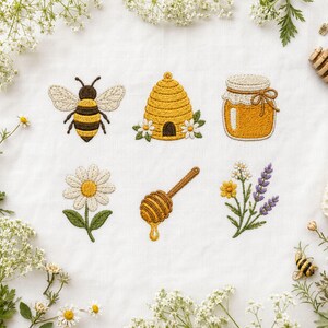 Puede incluir: Un patrón de bordado sobre tela blanca que presenta una abeja, una colmena amarilla con flores blancas, un tarro de miel con un lazo de cuerda marrón, una margarita blanca, un cazo de madera para miel y una rama de flores de lavanda.
